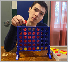 A young man playing connect 4